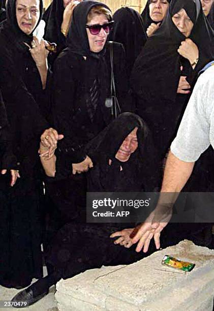 Ezzat, the mother of Iranian-Canadian journalist, Zahra Kazemi, on the ground , weeps in front of her daughter's grave in the cemetery of Sayyed...