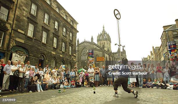 Street performer balances a unicycle on his face while entertaining the crowd during the 57th Edinburgh Festival Fringe 2003 August 5, 2003 in...
