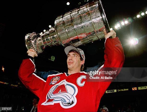 Joe Sakic, captain of the Colorado Avalanche carries the Stanley Cup trophy after defeating the Florida Panthers 1-0 in triple overtime of game four...