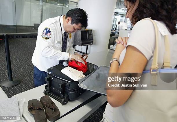 Transportation Security Administration screener inspects a bag at the international terminal of San Francisco International Airport August 5, 2003 in...