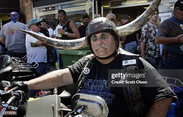 Arlen Strehlow, who traveled from Milwaukee, Wisconsin, watches as bikes and bikers parade by at the annual Sturgis Motorcycle Rally August 5, 2003...