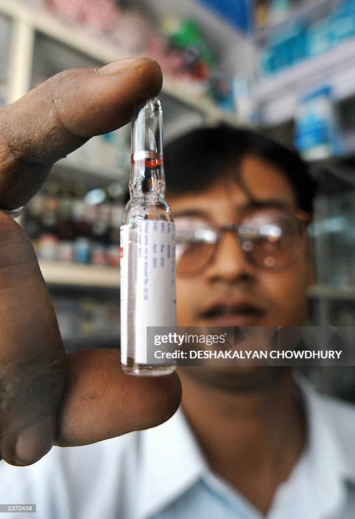 An Indian pharmacy shop assistant checks