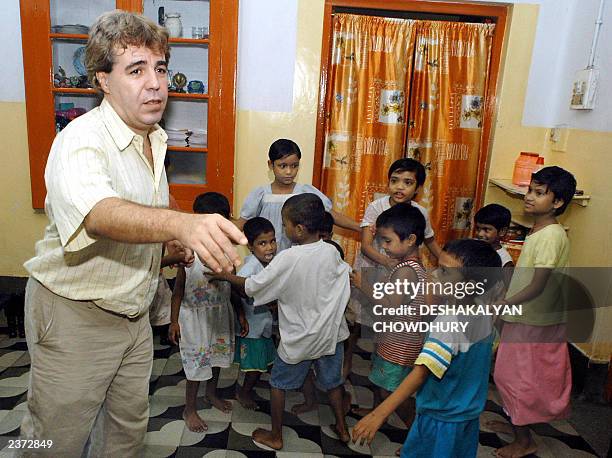 This picture taken 01 August 2003 shows Thierry Darnaudet, a French social worker and head of the NGO "New Light", dancing with a group of Indian...