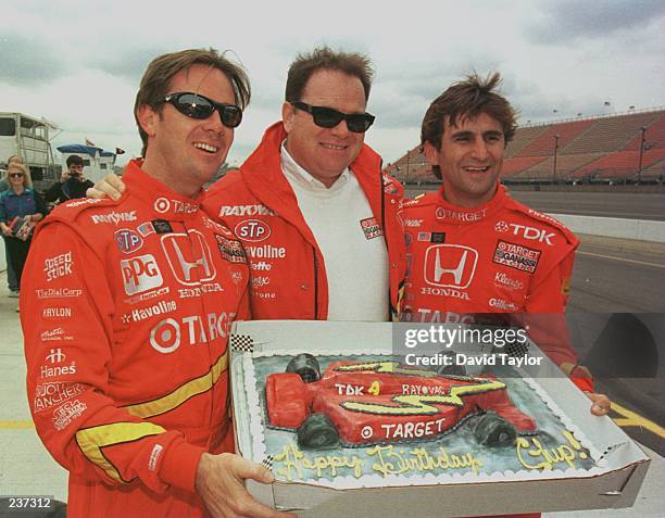 Pole Position holder Jimmy Vasser and Target Ganassi teammate Alessandro Zanardi of Italy presents team owner Chip Ganassi with a birthday cake in...