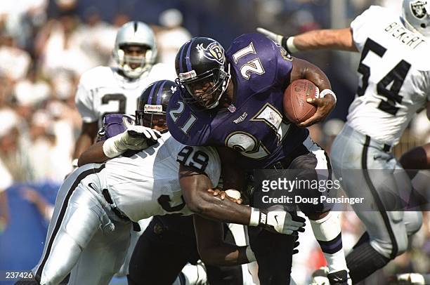 Running back Earnest Byner of the Baltimore Ravens uses his right arm in attempts to fight through the tackle of defensive lineman Aundray Bruce of...