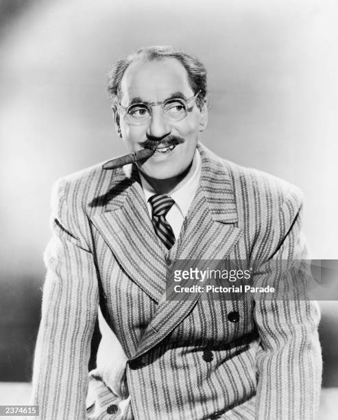 Studio portrait of American actor and comedian Groucho Marx smiling with a cigar, circa 1945.