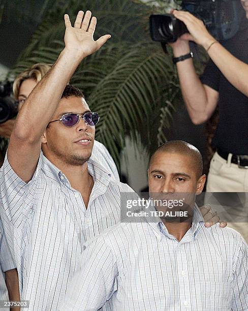 Real Madrid's Ronaldo waves as Roberto Carlos stands at right shortly after arriving at Hong Kong International airport, 06 August 2003. Real Madrid...