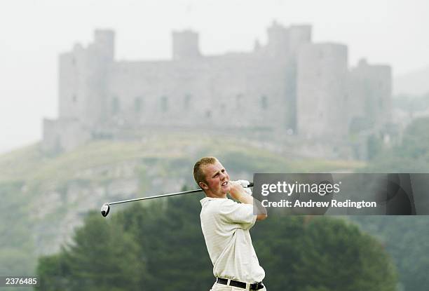 Aaron O'Callaghan of Ireland tees off on the 14th hole with Harlech Castle behind during his match with Paul O'Hanlon against Daniel Denison and Ben...