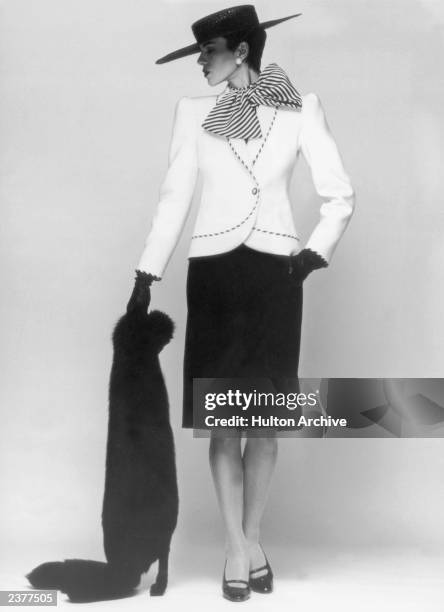 Suit from the Pierre Balmain Spring/Summer 1983 collection, 26th January 1983. A white jacket is worn over a black woolen skirt and a black and white...