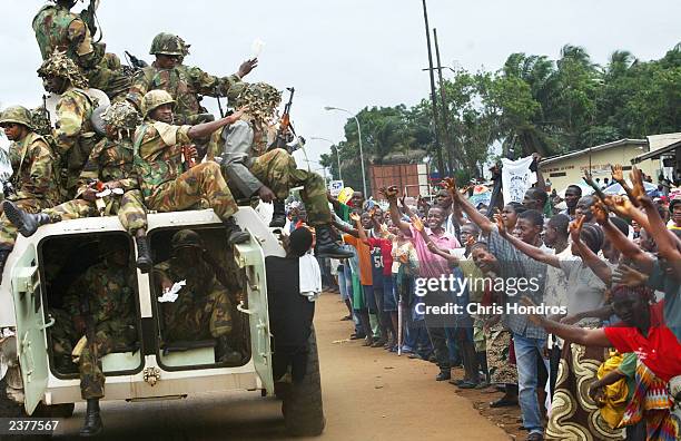 Nigerian peacekeepers drive past cheering crowds as they make their first rounds through the center of Monrovia August 7, 2003 in Monrovia, Liberia....