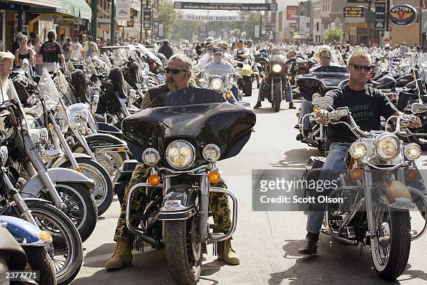 Bikers cruise during the annual Sturgis Motorcycle Rally August 7, 2003 down Main Street in Sturgis, South Dakota. The weeklong rally attracts an...