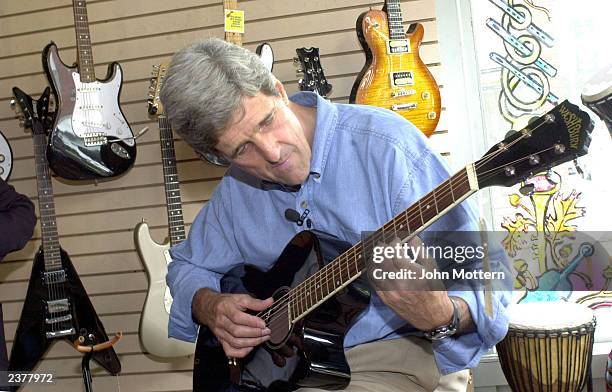 Democratic Presidential hopeful Senator John Kerry plays guitar at Northern Lights Music store during a walk around campaign tour on Main Street...