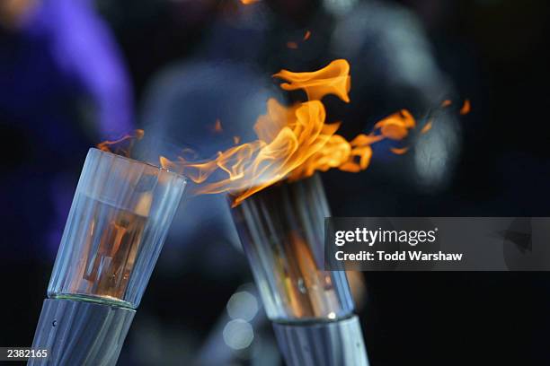 The Olympic Flame is passed between two torches during the 2002 Salt Lake City Olympic Torch Relay on February 8, 2002 in Taylorsville, Utah.