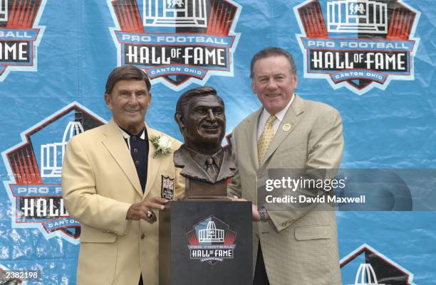 Pro Football Hall of Fame inductee Hank Stram poses with his bust and his presenter and fellow Hall of Famer Len Dawson during the 2003 NFL Hall of...