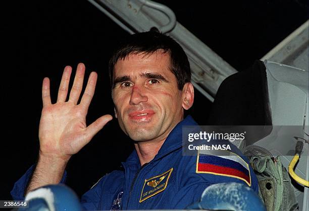 While preparing for the fourth launch to the International Space Station, STS-106 Mission Specialist Yuri I. Malenchenko waves for the camera as he...