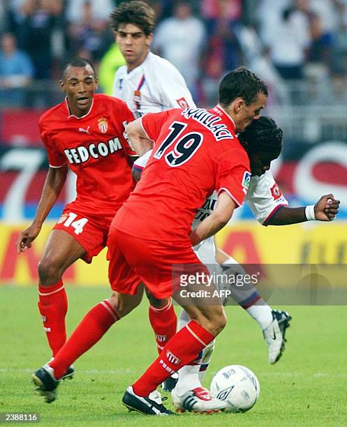 Lyon's striker Peguy Luyindula fights for the ball with Monaco's defender Sebastien Squillaci and midfielder Edouard Cisse as his teammate Brazilian...