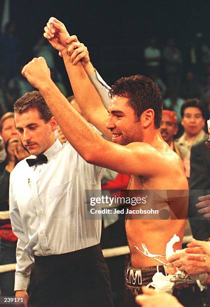 Oscar De La Hoya celebrates as referee Mitch Halpern raises his hands in victory following his second round technical knock out of Darryl Tyson at...