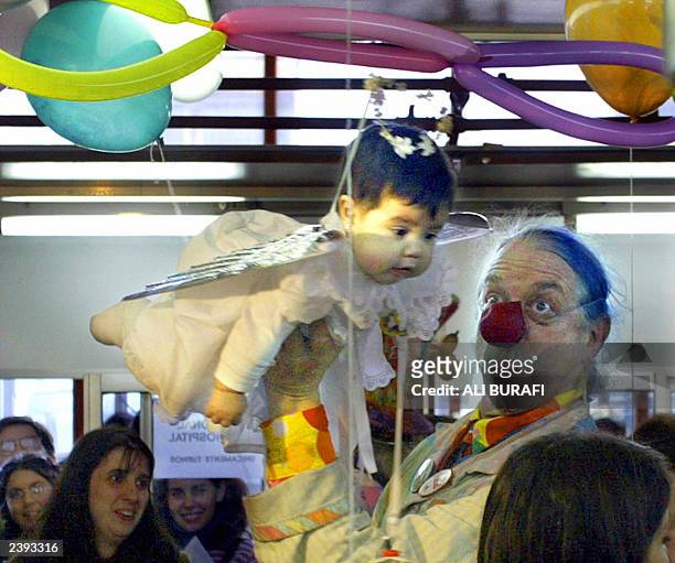 Doctor Hunter "Patch" Adams jokes with a baby at the Garragan Children Hospital,12 August 2003 in Buenos Aires. Adams, who developed a humour therapy...