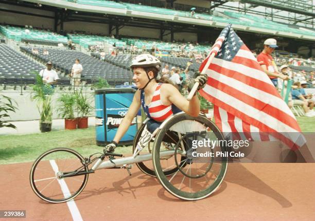 Leann Shannon of the USA waves an American flag in celebration as she takes a victory lap following her gold medal performance and new world record...