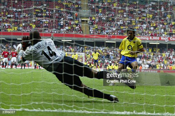 Tim Howard of Manchester United saves the final penalty from Robert Pires of Arsenal during the FA Community Shield match between Arsenal and...