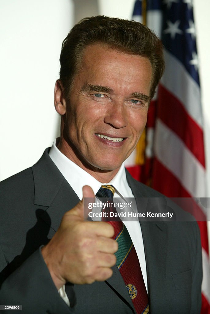 Actor Arnold Schwarzenegger gives a thumbs-up at his office August 8