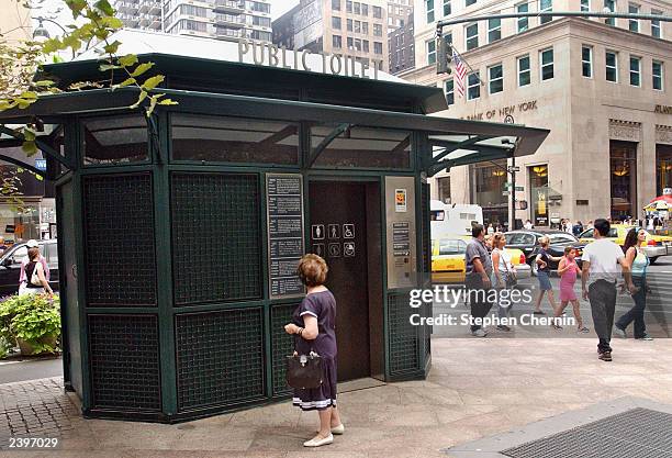 Woman reads the information panel on a public toilet located in Herald Square August 13, 2003 in New York City. New York City Mayor Michael Bloomberg...