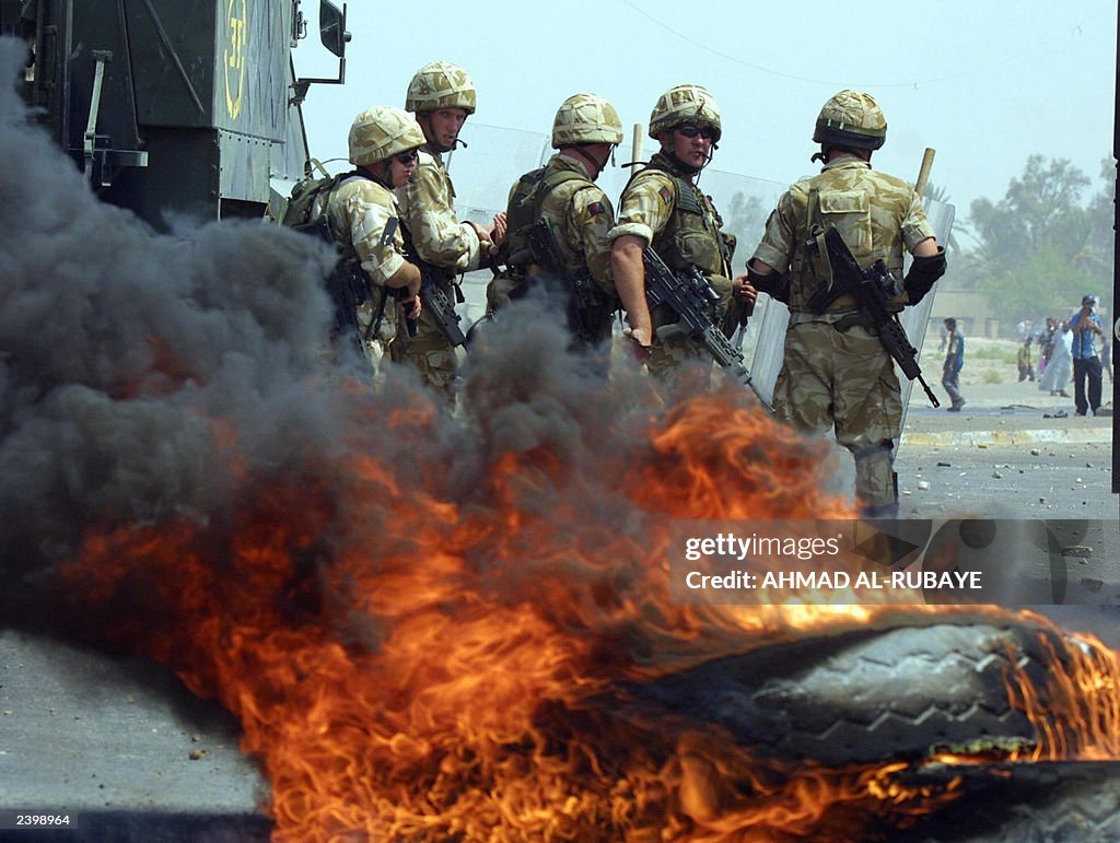 British soldiers stand by burning tires 