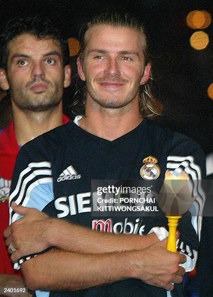 Real Madrid's David Beckham holds a candle to celebrate the birthday of Thai Queen Sirikit following their match against host Thailand in Bangkok, 10...