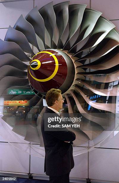Member of staff from British company Rolls Royce stands in front of a giant engine model during the Taipei Aerospace Technology Exhibition at the...