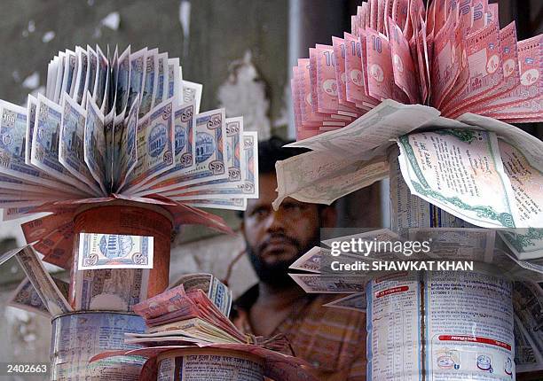 Bangladeshi money dealer displays clean bundles of Taka, the country's currency, in his shop, in Dhaka, 07August 2003. Many of the notes which are in...