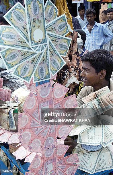 Bangladeshi money dealer displays clean bundles of Taka, the country's currency, in Dhaka, 07August 2003. Many of the notes which are in circulation,...