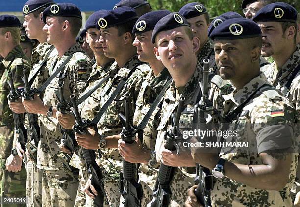 Soldiers from the International Security Assistance Force stand on parade at the ceremony marking the ISAF change of command from joint German-Dutch...