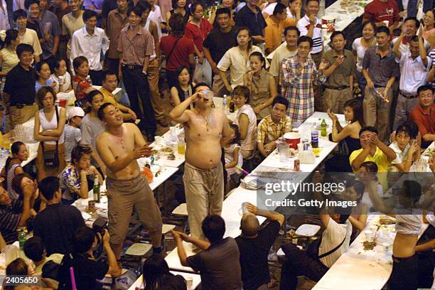 Man finishes his beer while having a drinking contest in a beer hall at the 13th Qingdao International Beer Festival August 17, 2003 in Qingdao,...