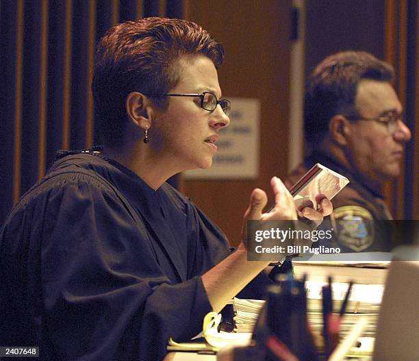 Macomb County Circuit Court Judge Deborah Servitto examines a rap CD that was handed to her by Marshall Mathers attorney Pete Peacock August 18, 2003...