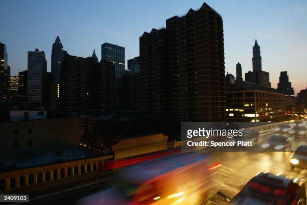 Cars head over the Brooklyn Bridge beside a blacked out New York City skyline August 14, 2003 during a power outage. The New York City comptroller...