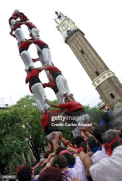 Young 'Castellier' reaches the summit of a human tower during the "Fiesta Major de Gracia" on August 17, 2003 in Barcelona, Spain. This Catalan...