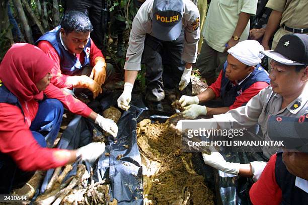 An Indonesian police and Indonesian red-cross activists collect bones, assumed of Indonesian military soldier M. Juni Cut who was kidnaped on 20...