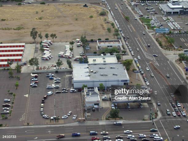 In this aerial view, motorists line up in a circular pattern at left and down the street at right after following a tanker truck into a gas station...