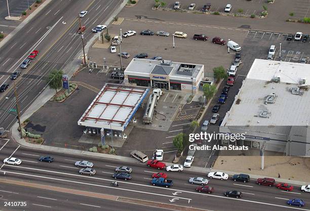 In this aerial view, motorists line up in a circular pattern at top and down the street at lower right after following a tanker truck into a gas...