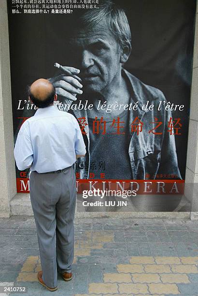 Man looks at a poster promoting the well-known Czech writer Milan Kundera's work "The unbearable lightness of being" at a book store in Shanghai, 19...