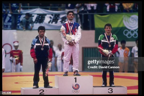 John Smith of the United States stands with Stepan Tarkissian of the Soviet Union and Simeon Chterev of Bulgaria after being awarded medals in the 62...