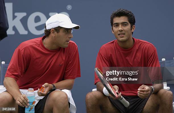 Amir Hadad of Israel confers with partner Aisam-Ul-Haq Qureshi of Pakistan while playing Wayne Black and Kevin Ulyett both of Zimbabwe during the US...