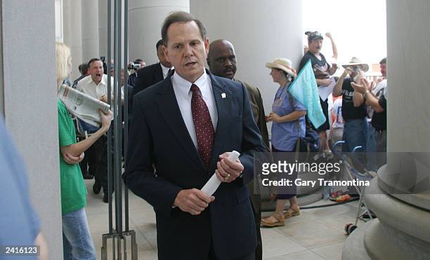 Alabama Supreme Court Chief Justice Roy Moore walks back into the state Judicial Building after addressing supporters August 21, 2003 in Montgomery,...