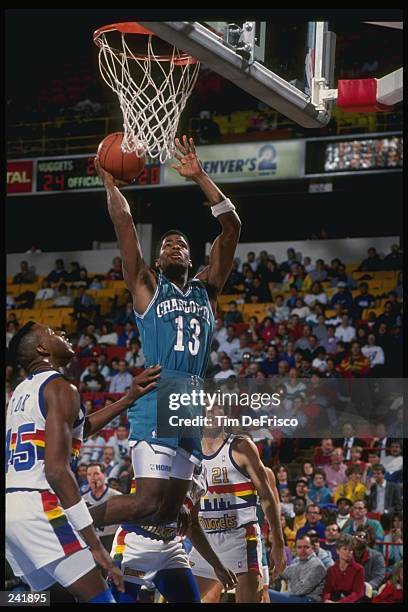 Guard Kendall Gill of the Charlotte Hornets goes up for two as forward Anthony Cook of the Denver Nuggets waits for the rebound during a game at the...