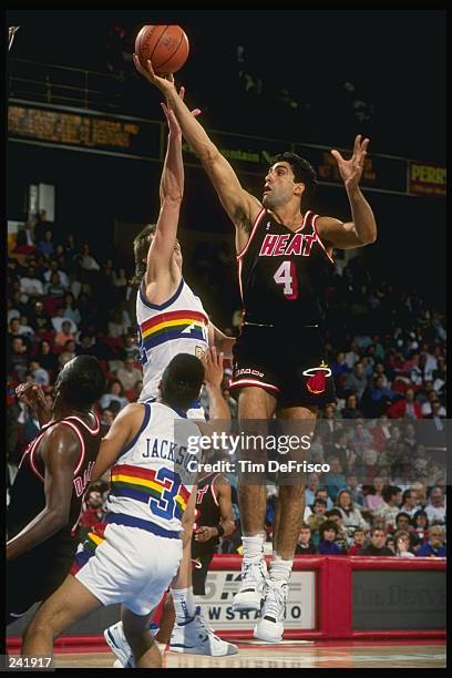 Center Rony Seikaly of the Miami Heat goes up for the layup past center Joe Wolf and guard Chris Jackson of the Denver Nuggets during a game at the...