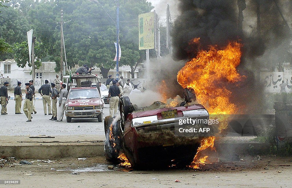 Pakistani policemen stand guard behind a