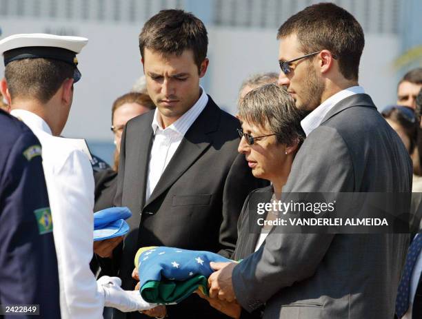 Brazilian Navy cadet gives to slain UN diplomat Sergio Vieira de Mello's sons Adrian and Bernard and widow Annie the Brazilian and UN flags, during a...