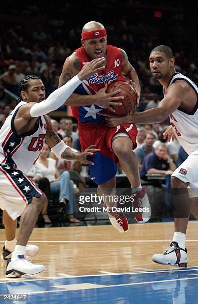 Elias Ayuso of Puerto Rico splits the defense of Allen Iverson and Tim Duncan of the USA during an exhibition game on August 17, 2003 at Madison...