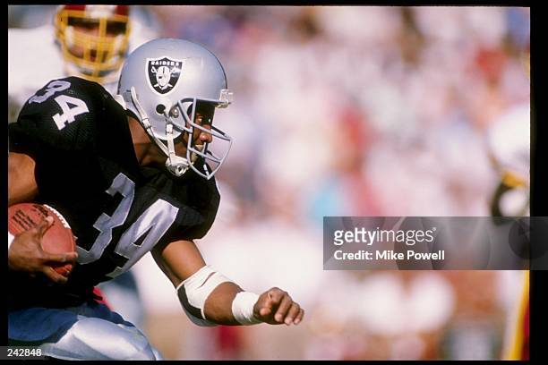 Running back Bo Jackson of the Los Angeles Raiders runs with the ball during a game against the Washington Redskins at the Los Angeles Memorial...