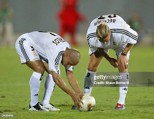 David Beckham and team-mate Roberto Carlos of Real Madrid both prepare for a free-kick during the Spanish Super Cup Ist leg match between Real...